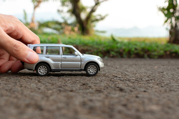 Concept for outdoor activities with toy for children. Photo of a toy car held by hand. After some edits.