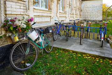 Fototapeta na wymiar Bicycle parking for retro bicycles near an old brick house