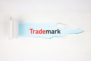 TRADEMARK text, acronym on torn paper. Trademark concept.