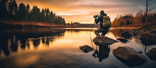 A man photographer on a beautiful lake. - obrazy, fototapety, plakaty
