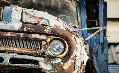 Detail of an old rusty car in a junkyard.