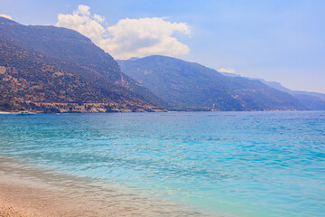 Fototapeta premium View of the mountains and the sea from Oludeniz beach, the blue lagoon. The cleanest beach with blue flag. Background