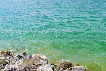 Rocky shore of a fresh reservoir. Background with selective focus and copy space
