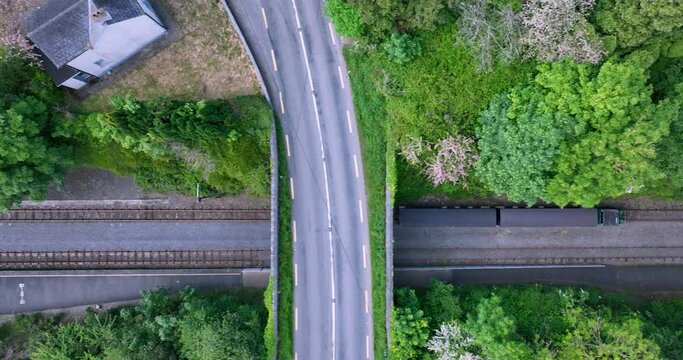 A train passes under a bridge. Waterford Suir Valley Railway 4k