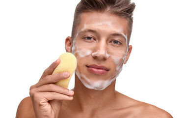 Young man washing his face with sponge on white background