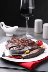 Delicious grilled beef meat served on grey table, closeup