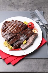 Delicious grilled beef meat served on grey table
