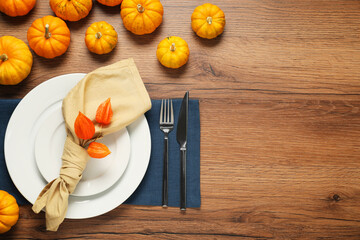 Stylish autumn table setting on wooden background, flat lay. Space for text