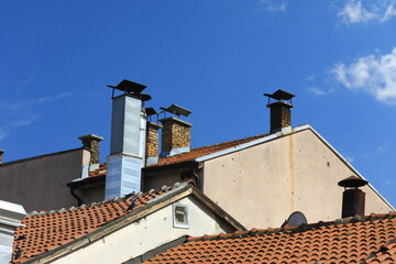 Village roofs with multiple chimneys in the sky