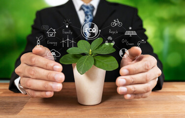 Businessman holding plant symbolize environmental protection by corporate ESG commitment to make...
