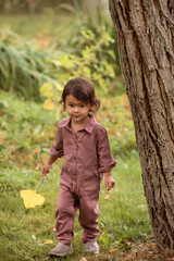 Happy toddler girl walking at nature in the fall, candid childhood and autumn season concept