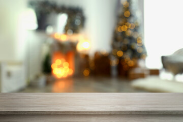 Empty wooden board in room decorated for New Year celebration, space for design