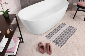 Stylish bathroom interior with soft bath mat and tub, above view