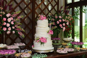 Fototapeta na wymiar birthday table, birthday cake decorated with flowers, pink flowers, birthday cake, cake close-up, white cake, cake with flowers, birthday candle, pink and white flowers