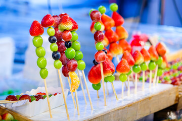 traditional Chinese snack Tanghulu or mix Fruits on skewers coated in a crispy shell of sugar