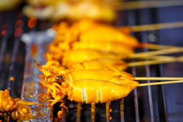 grilled squid with yellow sauce in street food market