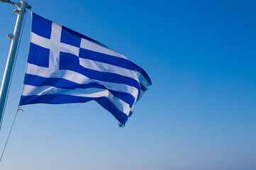 A Greek flag in a ferry from Athens to Mykonos Island caught flying in the wind.