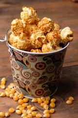 caramel popcorn in the bucket-shaped container. sweet dessert made from corn kernel and melted sugar