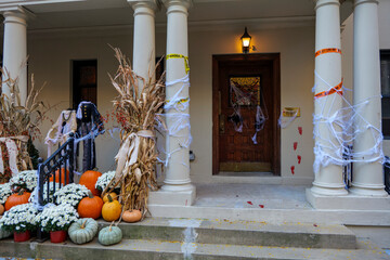 Colorful Pumpkins and Flowers on the Stairs of an Old Brownstone Home in New York City during...