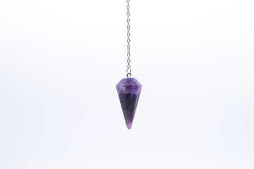 Purple Amethyst crystal pendulum on chain isolated on white background. - obrazy, fototapety, plakaty