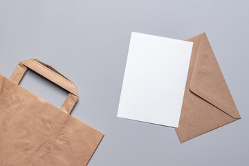 Craft envelope, blank form and craft bag on a gray background. Holiday shopping and gift concept.
