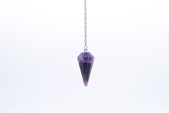 Purple Amethyst crystal pendulum on chain isolated on white background.