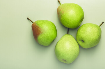 Group of ripe green pears on a greenish background, layout, banner. Freshness, organic fruit concept.