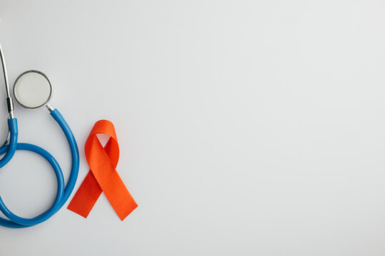 Isolated on white, a top view of stethoscope and red AIDS ribbons. Signifying hope, support, and healthcare in the fight against HIV. Give me this.