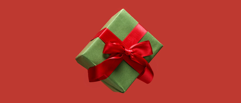 Flying gift box on red background