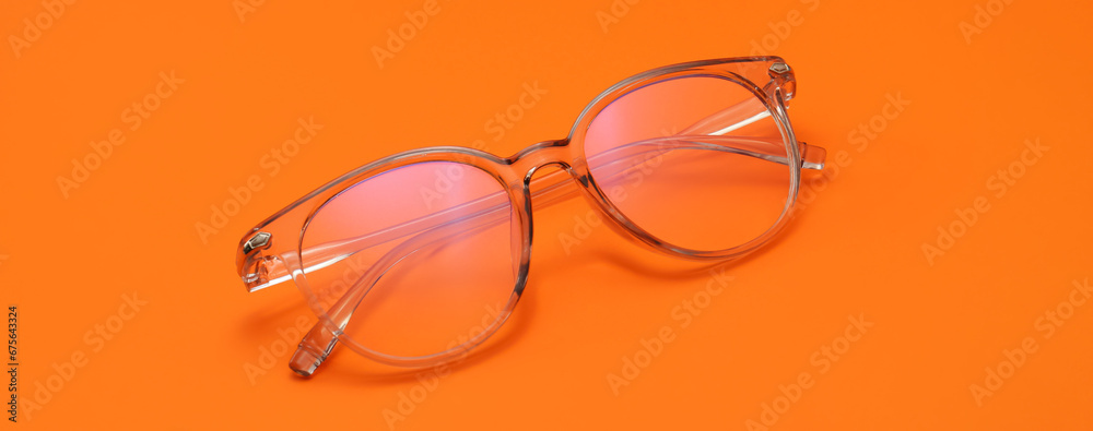 Poster stylish eyeglasses on orange background