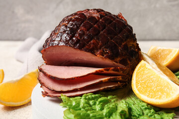 Plate with tasty smoked ham and lemon slices on table