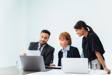 Obraz premium Three smiling diverse business colleagues having business strategy meeting.