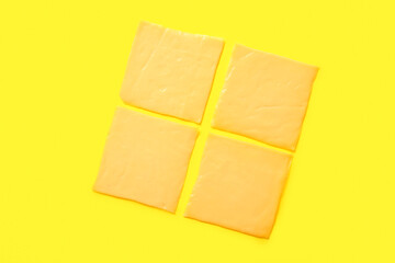 Slices of tasty processed cheese on yellow background