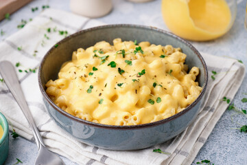 Bowl of tasty Italian pasta with Cheddar cheese on table