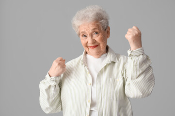 Happy senior woman on grey background