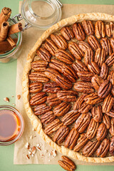 Tasty pecan pie on green background