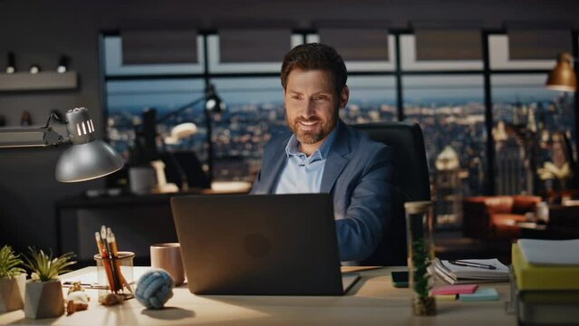 Smiling businessman taking coffee sip office night closeup. Boss looking laptop
