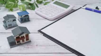 模型の住宅と電卓 白い紙のコピースペース
