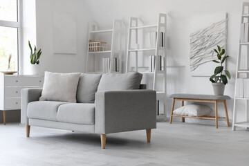 Modern living room interior with sofa, shelving unit and grey bench
