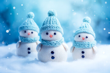 Cute snowmen in knitted hats and scarves on winter background