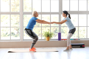 Fototapeta premium Mature woman training with therapist in rehabilitation center