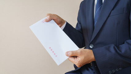 日本語の履歴書在中(朱書き)の封筒とビジネスマン│就職活動・転職活動イメージ