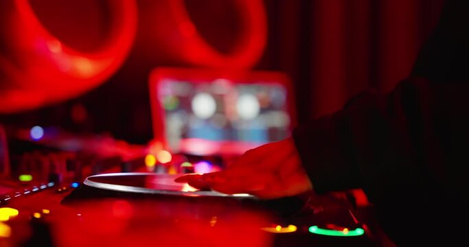 Close-up DJ Hand is adjusting fader on digital music console in neon light in nightclub. closeup. Concept of music on neon party.