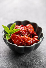 Bowl with sun dried tomatoes with fresh herbs and spices.