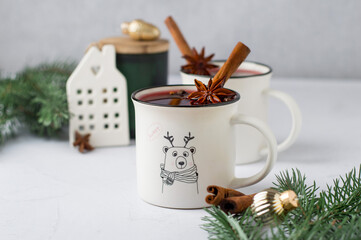 Celebrating, celebrating Christmas, New Year, preparing mulled wine. Cups with a pattern of red wine and spices, cinnamon, star anise, New Year decorations, decor. Light composition, horizontal.