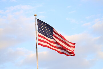 United States flag with blue sky and clouds in the background