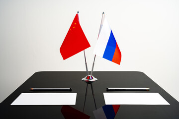 Russian and Chinese flags on negotiation table