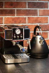 Morning coffee. Close up photo with a vintage coffee machine preparing an espresso drink in a white ceramic pot. Working from home environment in an industrial kitchen decor.