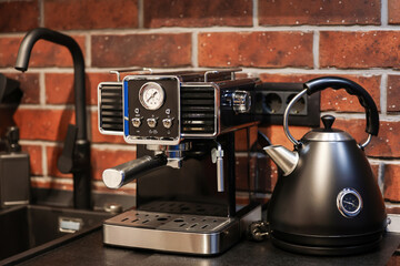 Morning coffee. Close up photo with a vintage coffee machine preparing an espresso drink in a white ceramic pot. Working from home environment in an industrial kitchen decor.