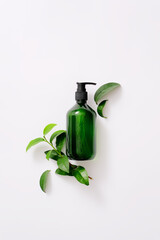 Top view of green homemade shampoo bottle with green tea extract on a white background. Green tea...